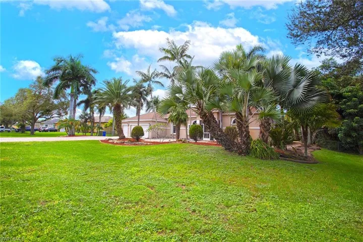 View of grassy yard featuring driveway