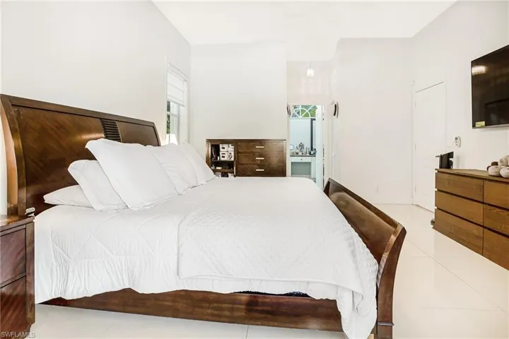 Bedroom featuring light tile patterned floors and ensuite bath