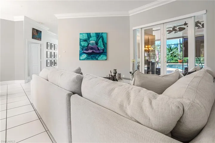 Living area with ornamental molding and light tile patterned floors