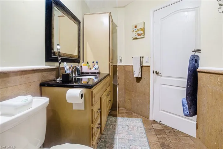 Bathroom with tile walls, wainscoting, and vanity