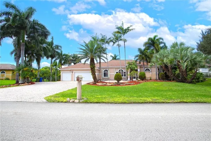 Single story home featuring decorative driveway, a front yard, an attached garage, and stucco siding
