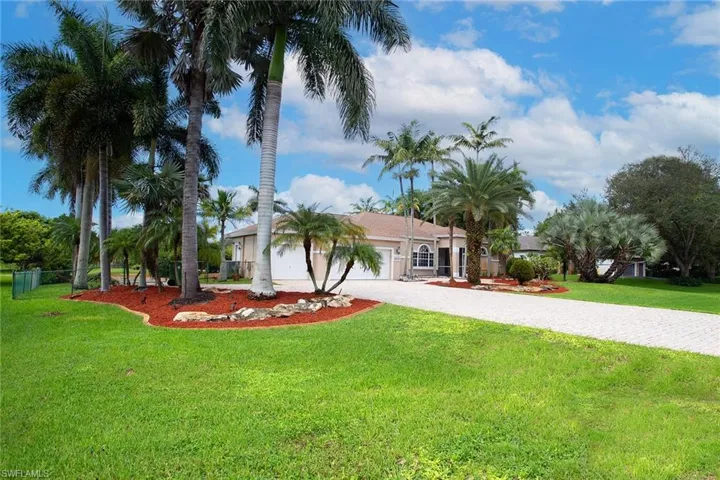 View of front facade with decorative driveway, a front lawn, and an attached garage
