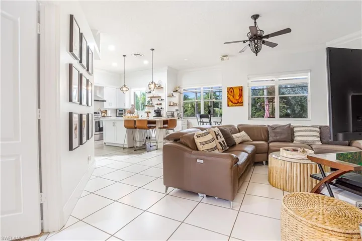 Living room featuring ornamental molding, light tile patterned floors, a ceiling fan, and recessed lighting