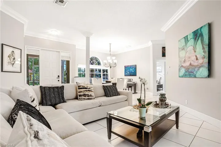 Living area featuring ornamental molding, a chandelier, and light tile patterned floors