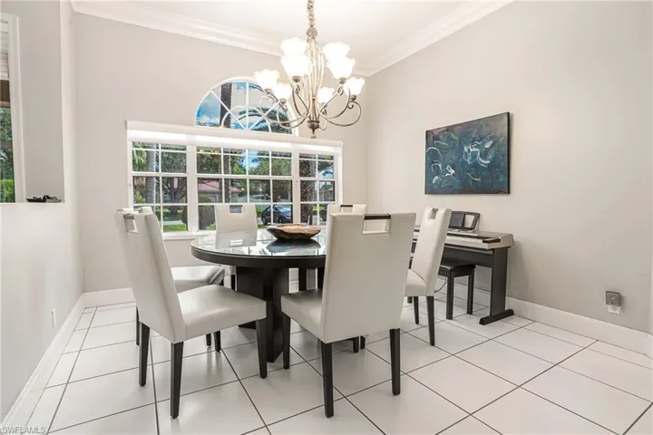 Dining space featuring crown molding, light tile patterned floors, and a chandelier