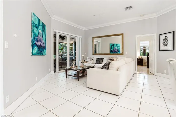 Living area featuring light tile patterned flooring and crown molding