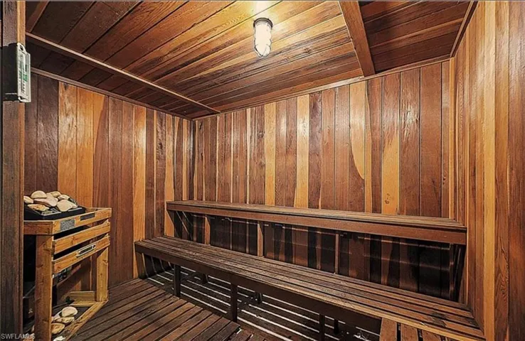 Sauna / steam room with wooden walls, wood ceiling, and hardwood / wood-style flooring
