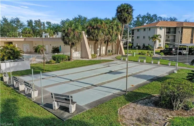 View of home's community with shuffleboard and a lawn