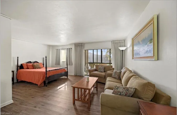 Bedroom featuring wood finished floors and baseboards