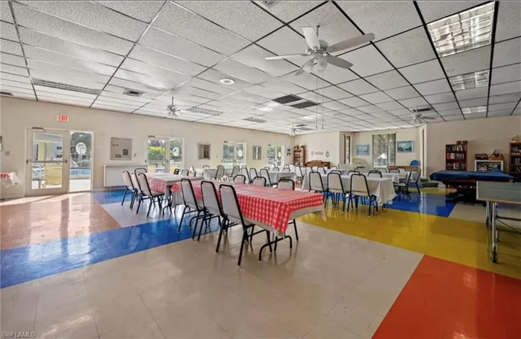 Dining area with ceiling fan, a paneled ceiling, and tile patterned floors
