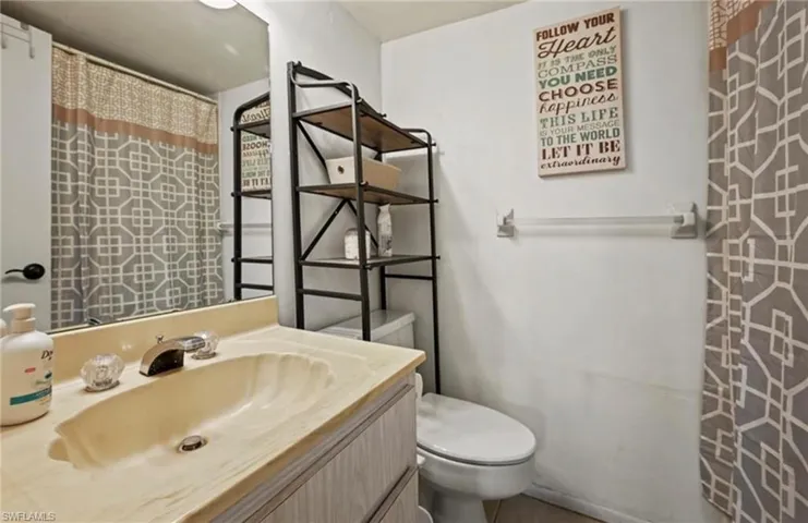 Bathroom featuring a shower with shower curtain and vanity