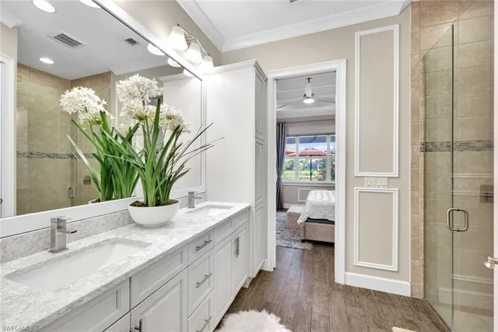 Master Bathroom with visible vents, crown molding, wood finished floors, and a sink