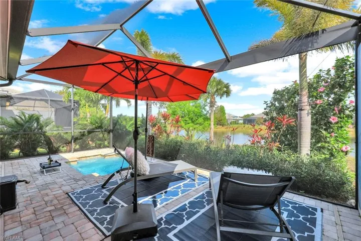 View of patio featuring screen enclosure and a water view