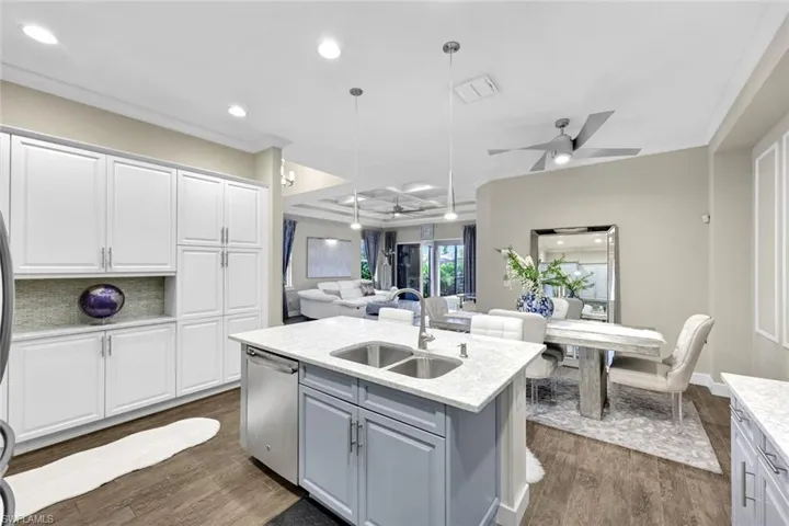 Kitchen with ceiling fan, a sink, stainless steel dishwasher, and open floor plan