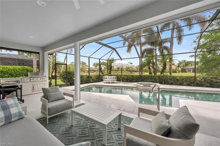 View of Swimming Pool with Outdoor Kitchen, Outdoor Covered Lanai/ Lounge Area, Pool with Connected Hot Tub, and  Screened Lanai