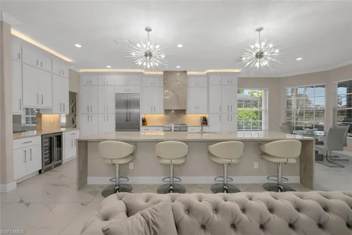 Kitchen Featuring Beverage Cooler, New Stainless Steel Thermador Refrigerator, 2 Chandeliers, Wall Chimney Exhaust Hood
