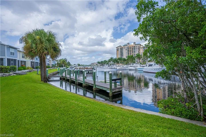 Dock area with a water view and a lawn