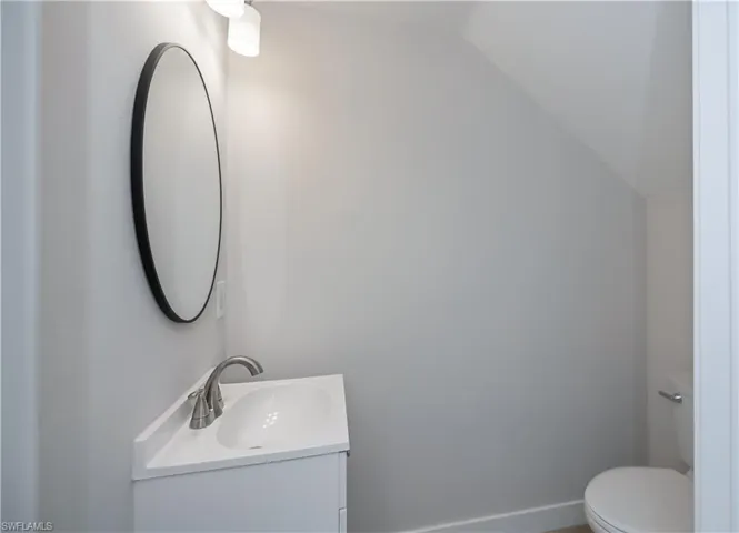 Half bath with vanity and vaulted ceiling