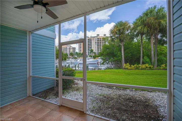 Unfurnished sunroom with ceiling fan and a water view