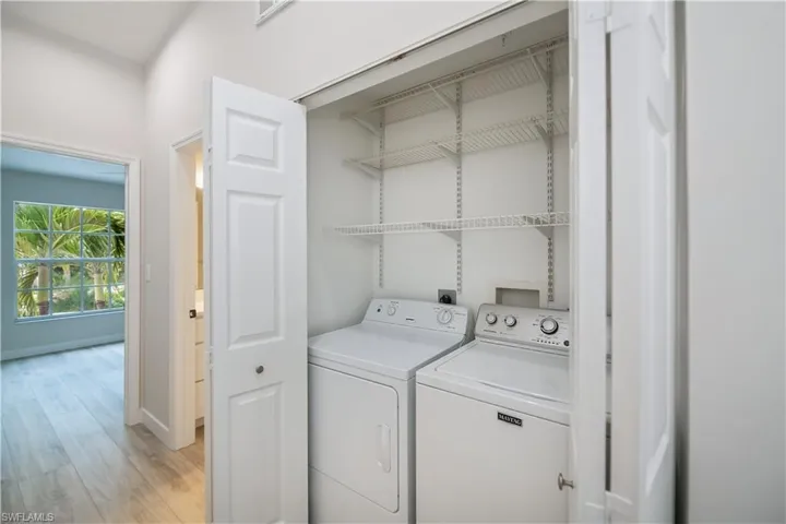 Laundry area featuring washing machine and dryer and light wood-style flooring