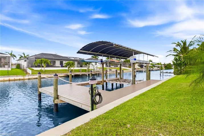 Waterfront dock with a boat lift, canopy, and direct canal access