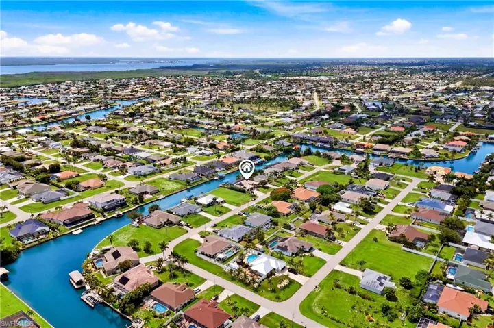 Aerial perspective showcasing a residential community with numerous properties situated along a network of canals
