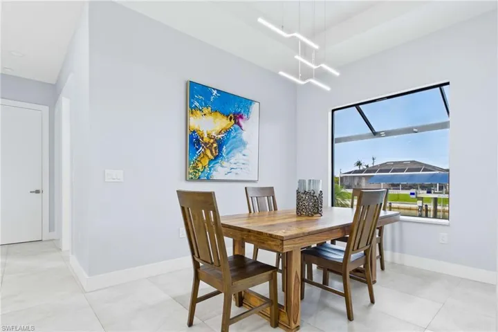 Dining area featuring large format tile flooring and a modern linear chandelier