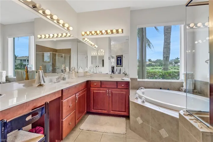 Bathroom featuring vanity, tile patterned flooring, plus walk in shower, and plenty of natural light