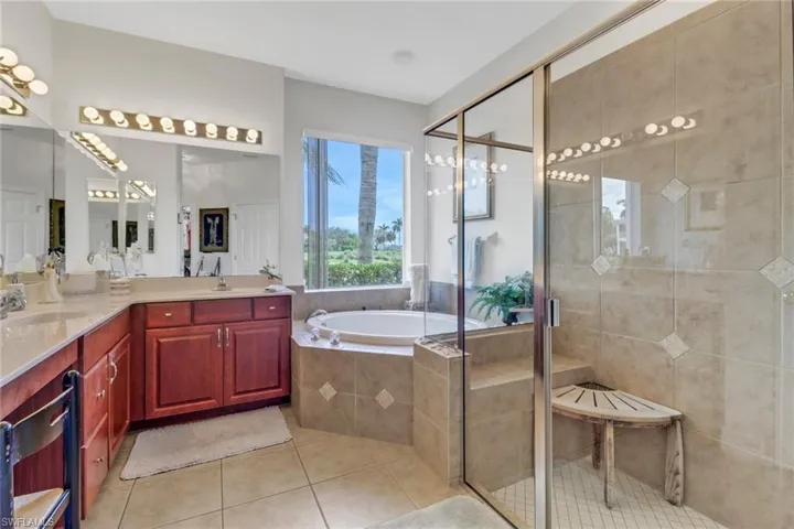 Bathroom featuring tile patterned flooring, vanity, and shower with separate bathtub