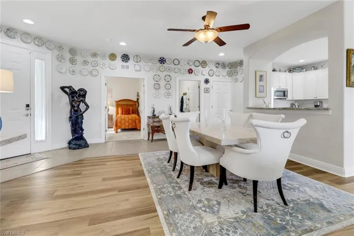 Dining area with ceiling fan and light wood-type flooring