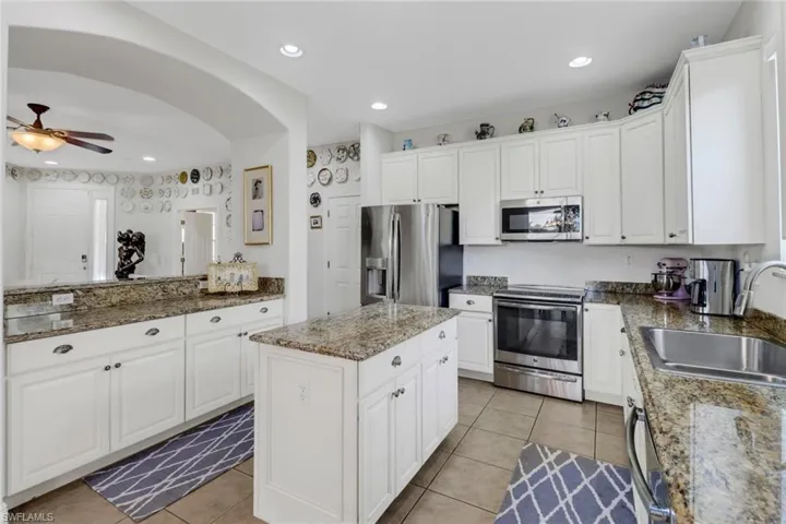 Kitchen with appliances with stainless steel finishes, white cabinetry, and sink