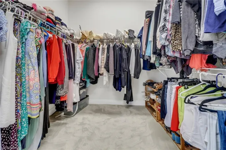 Walk in closet featuring light colored carpet