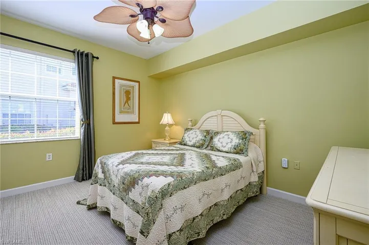 Bedroom featuring baseboards, ceiling fan, and light colored carpet