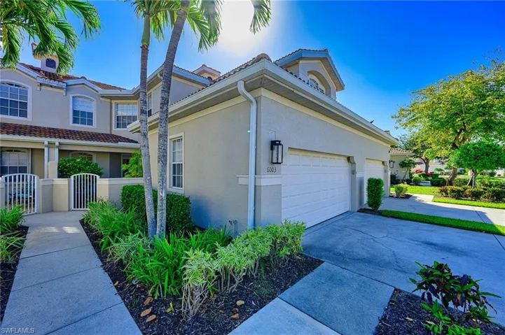 View of side of property featuring stucco siding, concrete driveway, and a garage
