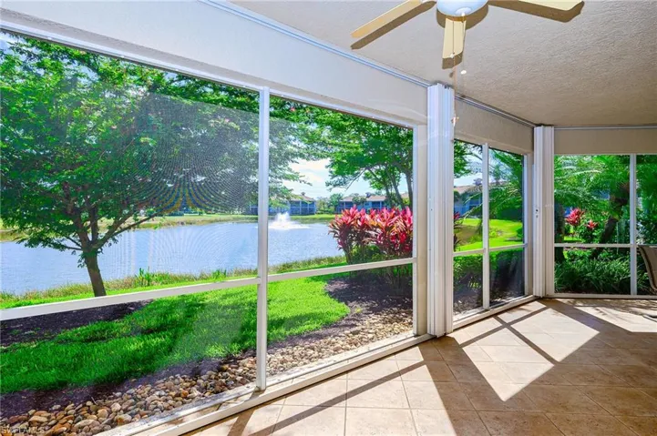 Unfurnished sunroom with tile patterned floors, a textured ceiling, and a water view