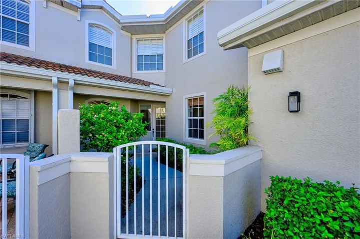 View of property exterior featuring fence, stucco siding, and a gate