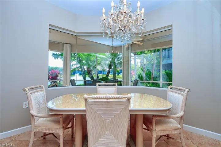 Dining area featuring an inviting chandelier, tile patterned floors, and baseboards