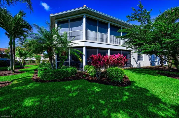 Rear view of property featuring a yard and a sunroom