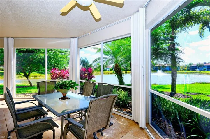 Sunroom featuring a textured ceiling, a water view, and tile patterned floors