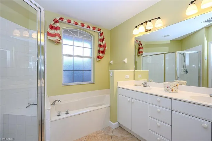 Bathroom with a shower stall, a sink, visible vents, a bath, and tile patterned floors