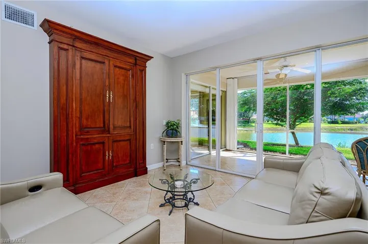 Living room featuring baseboards, visible vents, light tile patterned floors, and a ceiling fan