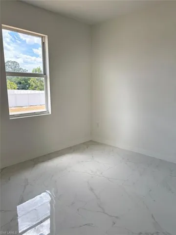 Empty room featuring baseboards and marble finish floors
