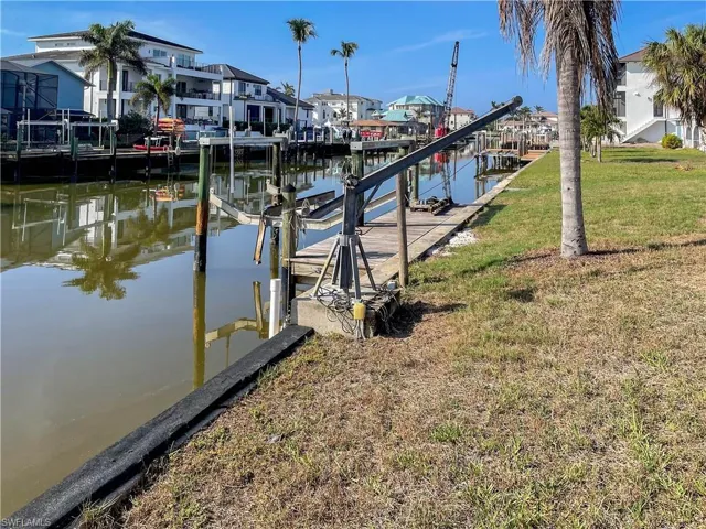 View of dock featuring a lawn and a water view