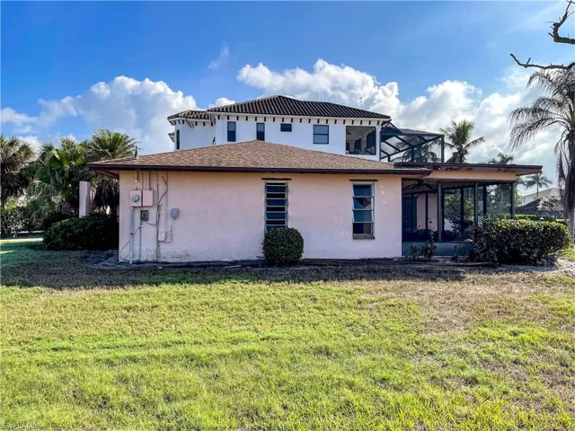 View of side of home featuring a sunroom and a yard