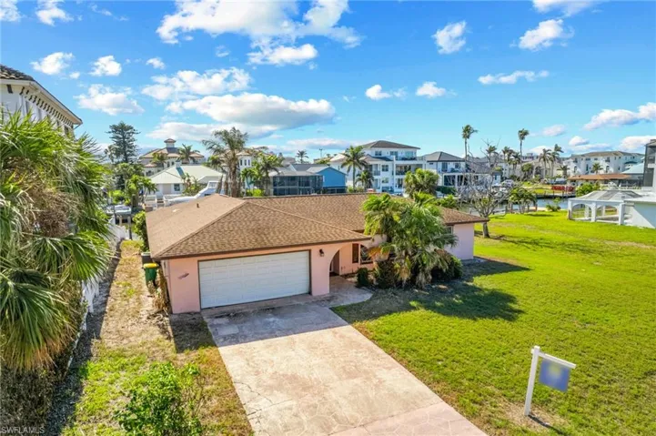 View of front of house featuring a front yard, a water view, and a garage
