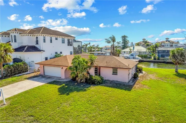 View of front facade featuring a garage, a water view, and a front yard