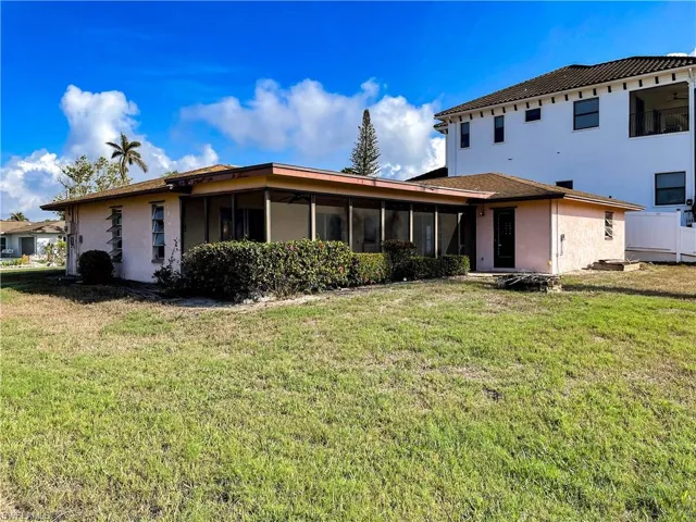 Back of property with a sunroom and a yard