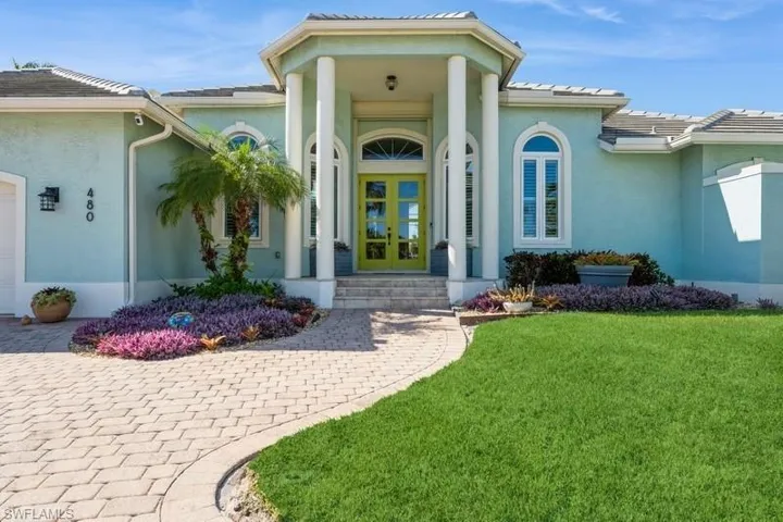 Property entrance featuring french doors, a yard, and a garage