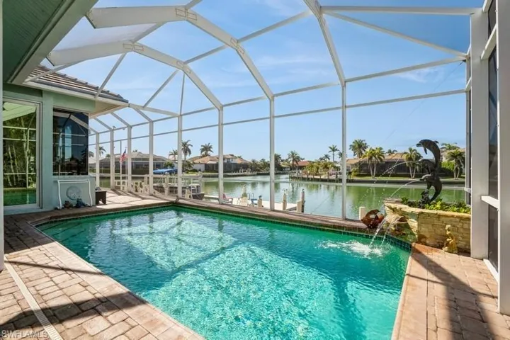 View of pool with pool water feature, a water view, a lanai, and a patio area