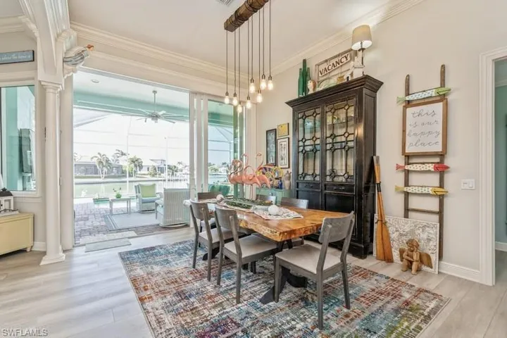 Dining area with decorative columns, plenty of natural light, and light wood-type flooring